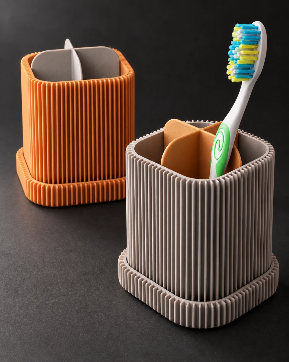Ribbed terracotta and grey bathroom cups holding a toothbrush